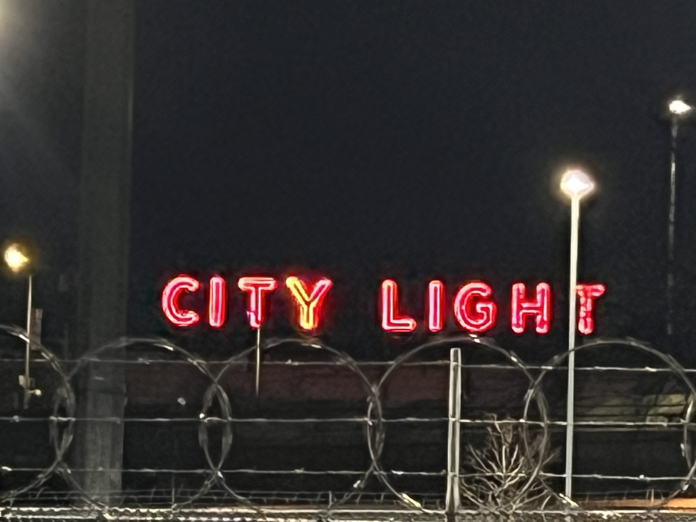 CITY LIGHT marquee letters in red neon, lit against the Ground Floor Studio at night.