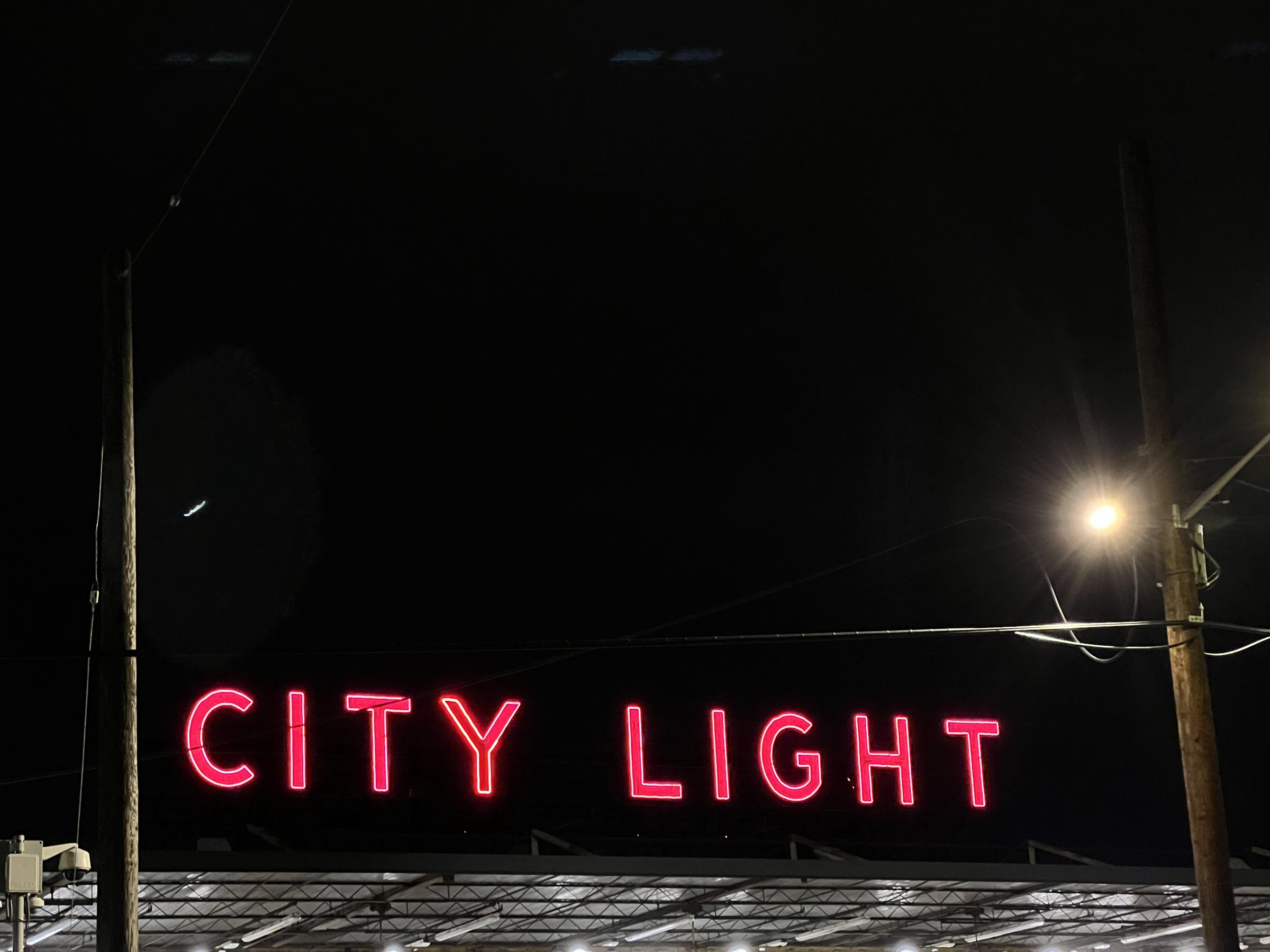 Wide view of the CITY LIGHT marquee lighting the studio frontage.