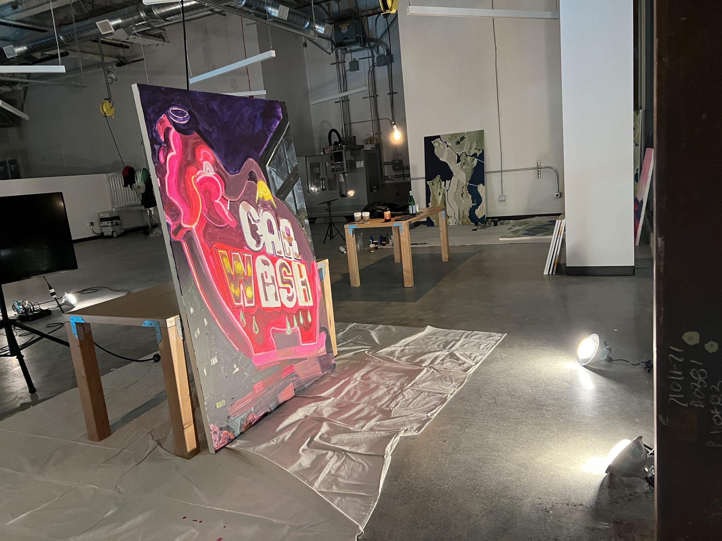 The Pink Elephant marquee painting taking form across a large canvas on the studio floor.
