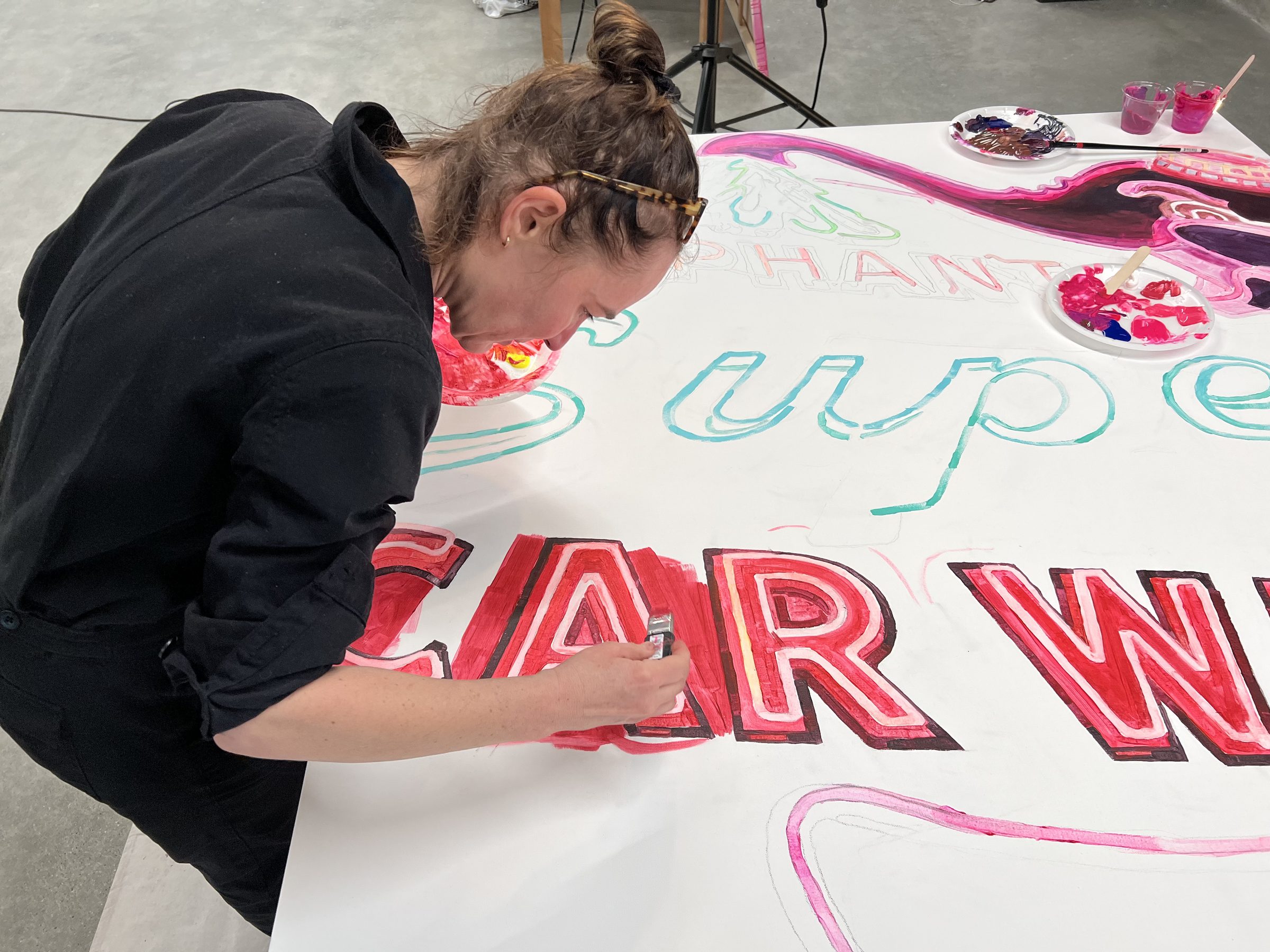 The CAR WASH panel further along, neon reds and magentas blooming.