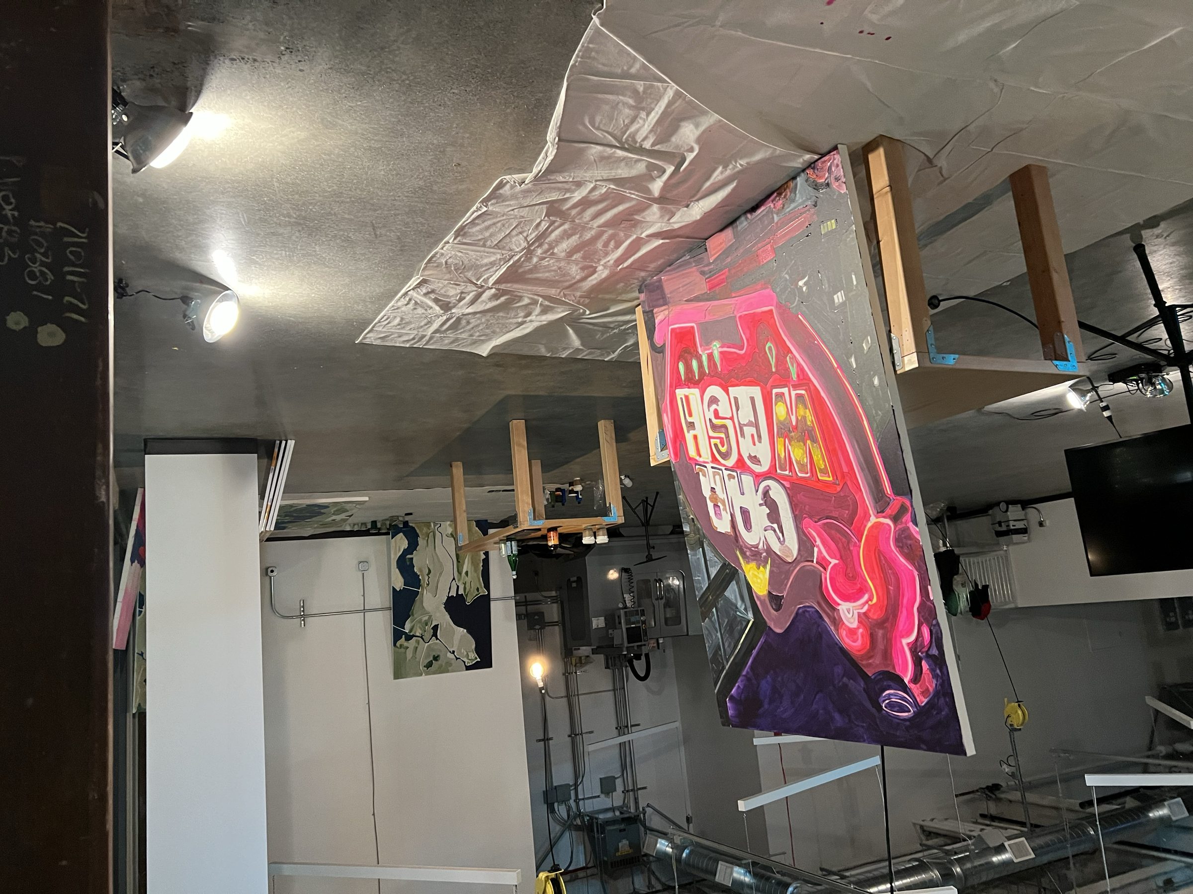 The Pink Elephant marquee painting taking form across a large canvas on the studio floor.